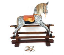 A dapple grey rocking horse on wooden stand, 127cm high x 124cm long overall