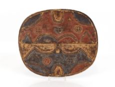 An African tribal shield, having painted stylised and raised decoration, 41cm x 35cm