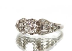 An antique platinum diamond solitaire ring, the central diamond in 8 claw setting with split and