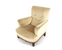A Late Victorian deep seated easy chair, upholstered in fawn buttoned Dralon raised on turned