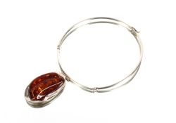 A large silver and amber pendant on silver collar