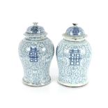 A near pair of Chinese blue and white baluster jars and covers, one with four character mark and wax