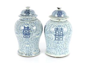 A near pair of Chinese blue and white baluster jars and covers, one with four character mark and wax