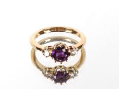 An unmarked yellow gold amethyst and diamond three stone ring, the central round amethyst in claw