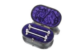 A cased pair of Edwardian silver knife rests, with ball terminals, Hallmarked Sheffield 1902,