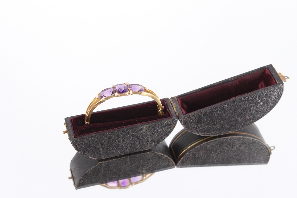 A Victorian unmarked gold bangle set three amethyst stones, flanked by seed pearls with safety chain - Bild 3 aus 3