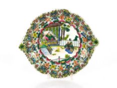 An Oriental famille rose decorated plate, having central scene of figures in an exotic garden