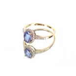 A 18ct gold tanzanite and diamond set ring, the oval tanzanite with brilliant cut diamond surround