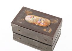 An early Victorian tin musical snuff box, the lid decorated with an enamel panel