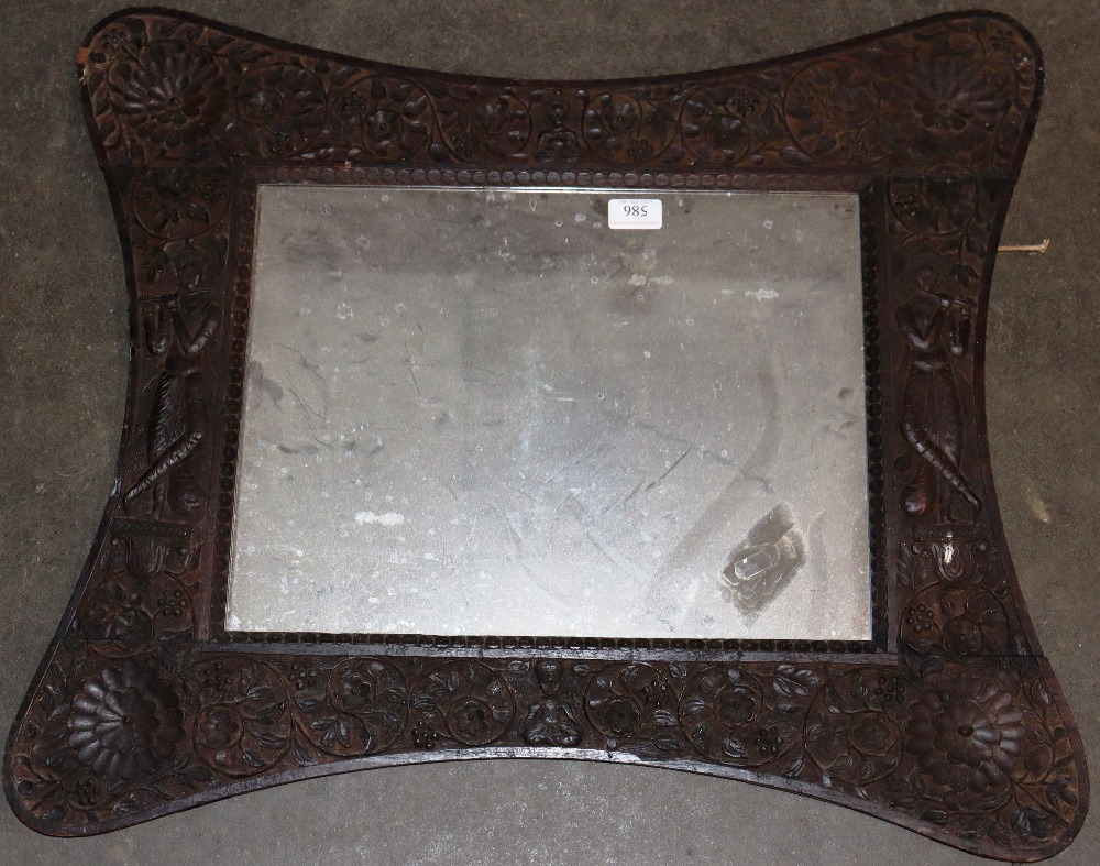 A carved Eastern wall mirror, profusely decorated