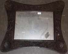 A carved Eastern wall mirror, profusely decorated