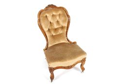 A Victorian walnut nursing chair in old gold buttoned upholstery, raised on carved cabriole front