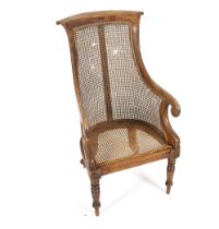 An early 19th Century mahogany Bergere chair, having scrolled arms raised on turned tapering