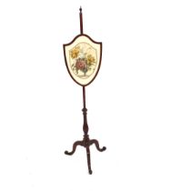 A 19th Century mahogany pole screen, the shield shaped banner decorated with printed fabric,