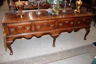 Early 18th Century oak dresser, having three plank top above four drawers with brass butterfly