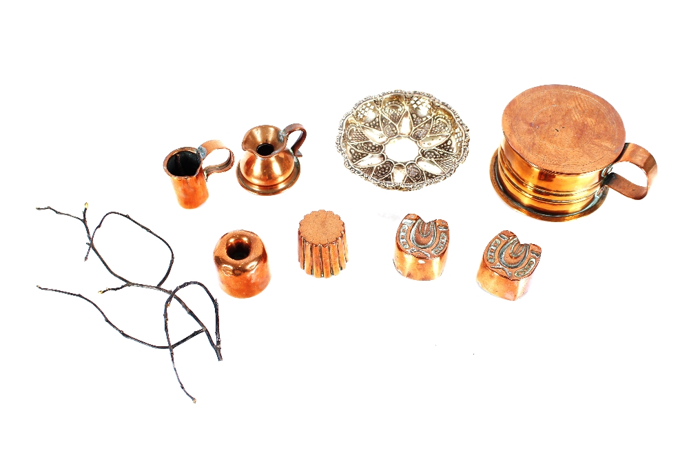 A small copper lidded bowl with handle; various copper moulds; a miniature copper jug; and a pierced