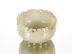 An unusual 19th Century Chinese jade cup decorated with lappets and archaic design on twelve short