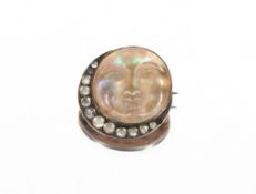 An Unusual Edwardian 9ct gold mounted curved opalescent glass "Man In The Moon" brooch with paste