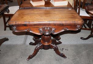 A Victorian rosewood card table, the fold over swivel top raised on an octagonal baluster column and