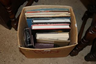 A box containing various books, records, wall cloc