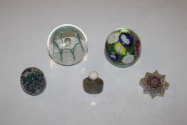A Caithness "May Dance" paperweight; three other paperweights and a polished stone snuff bottle