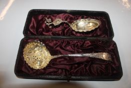 A cased silver sifter spoon with berry decoration,