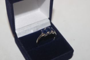 A silver ring set with three sapphire coloured sto