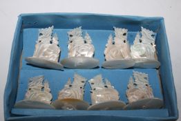 A boxed set of eight carved mother of pearl place