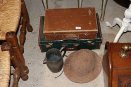Two suitcases; a metal jug and a tin helmet