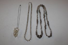 A white metal mounted necklace; a white stone bead