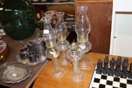 Four glass oil lamps, one lacking chimney