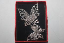 A boxed decorative butterfly brooch