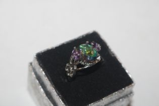 A white metal ring set with coloured stones