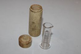 An etched glass measure, contained in carved bone
