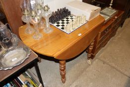 A cherry wood drop leaf dining table