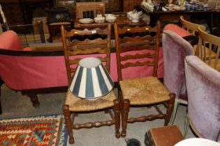 A pair of ladder back and rush seated dining chair