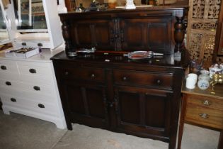 An oak court cupboard fitted two drawers, raised o