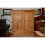 A pine double wardrobe fitted two drawers below