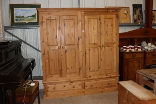 A pine double wardrobe fitted two drawers below