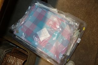 A box containing various bed covers and table nape