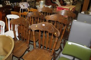 A set of six oak slat back chairs - four standards,