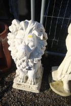 A plaster garden ornament in the form of a seated