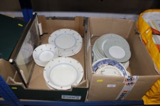 Two boxes containing various patterned dinnerware