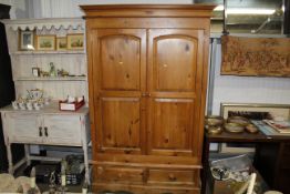 A modern pine two door wardrobe fitted two drawers
