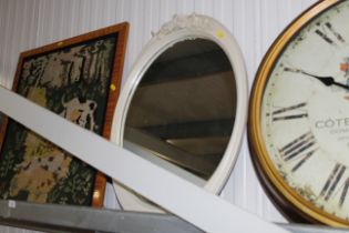 An oval framed wall mirror