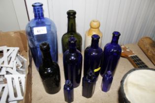 A collection of glass bottles and stoneware bottle