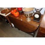An antique oak gate leg dining table