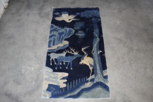 An approx. 4'11" x 2'8" rug decorated with landsca