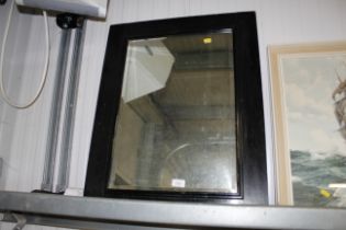 A framed bevelled edge wall mirror