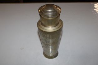 A silver plated cocktail shaker decorated with men